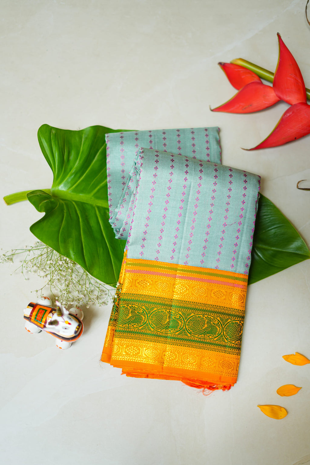 Aakasha silk saree: sky-blue dotted body, mango and leaf-green border (folded)