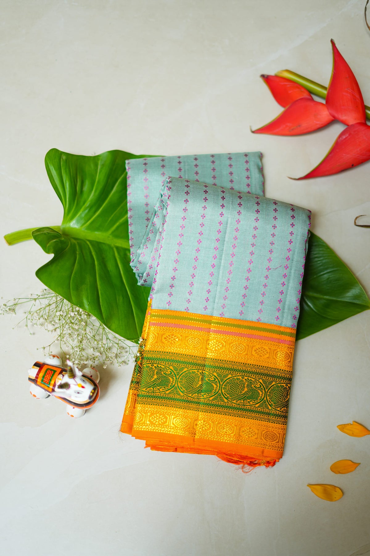 Aakasha silk saree: sky-blue dotted body, mango and leaf-green border (folded)