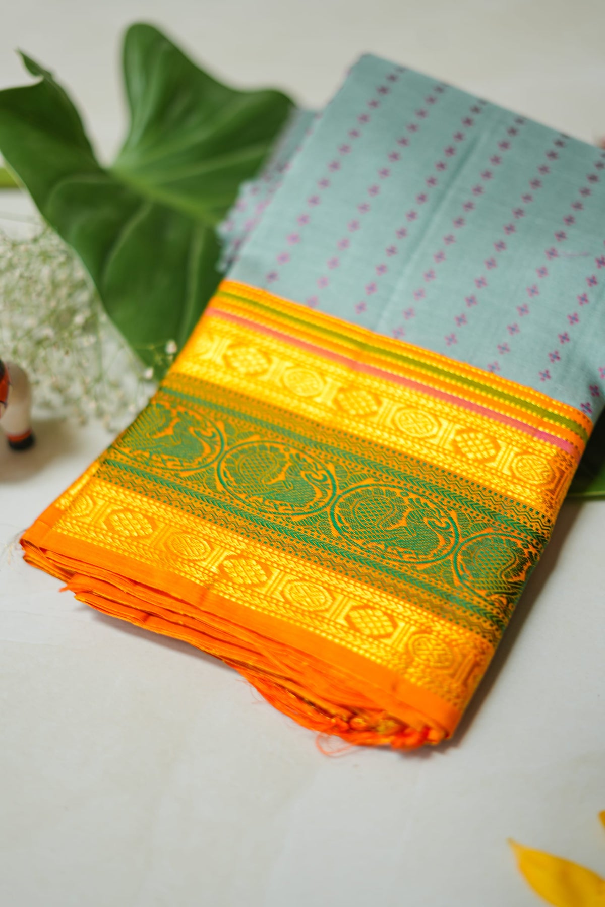 Aakasha silk saree: sky-blue dotted body, mango and leaf-green border (folded)