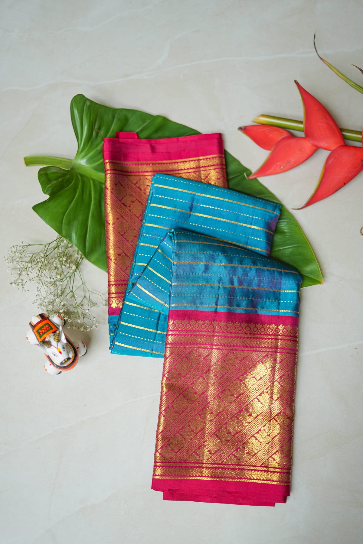 Turquoise Silk Saree with Gold Stripes: turquoise silk with gold zari stripes and a rani pink brocade pallu (folded)