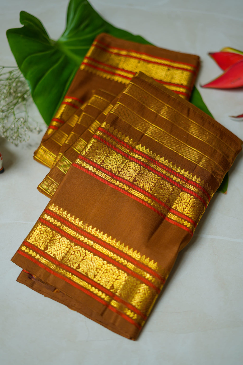 Brown Silk Saree with Copper Zari: chocolate-brown silk with a copper and gold zari border (folded)