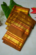 Brown Silk Saree with Copper Zari: chocolate-brown silk with a copper and gold zari border (folded)