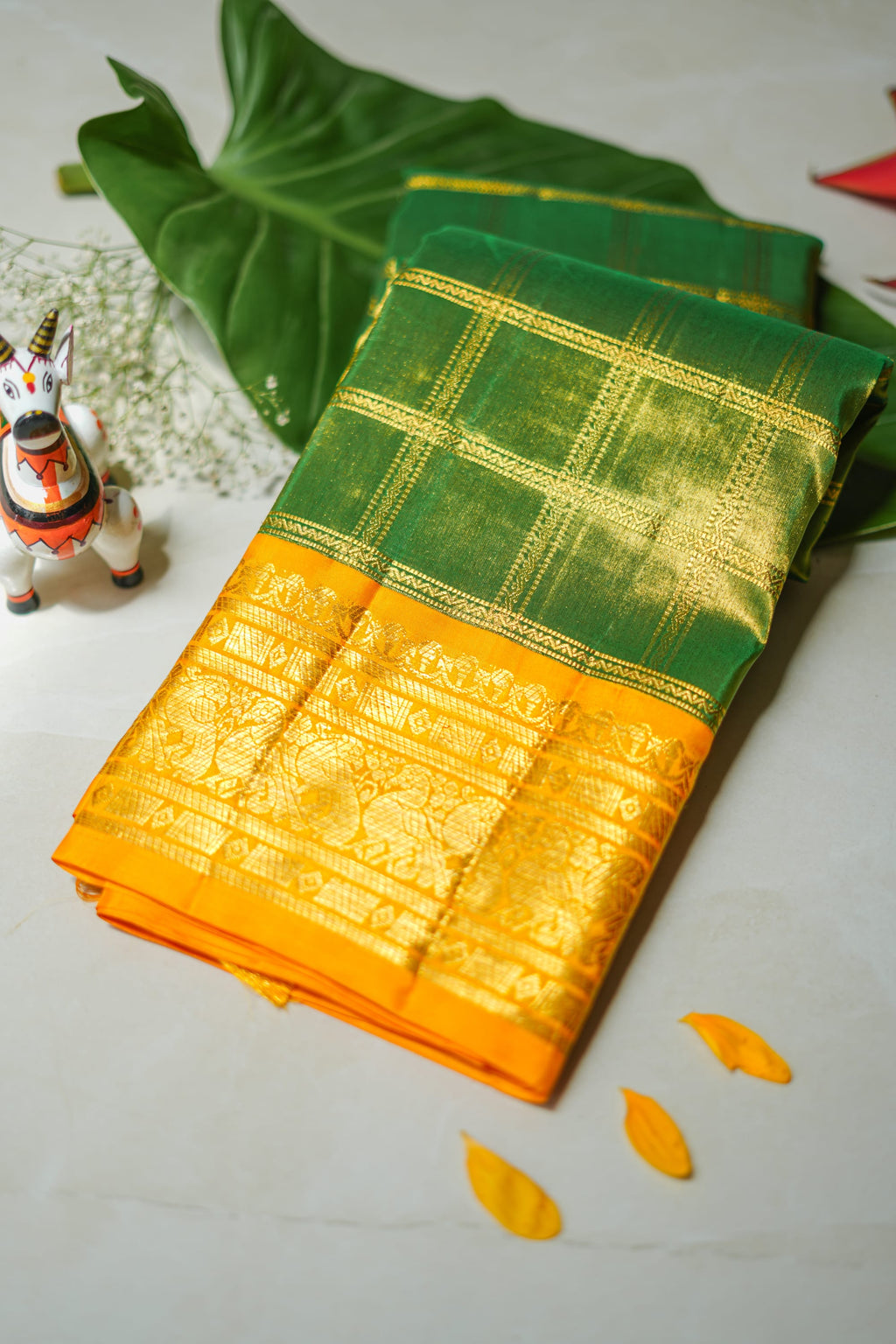 Green Silk Saree with Gold Checks: bottle-green silk with gold zari checks and a mustard border (folded)