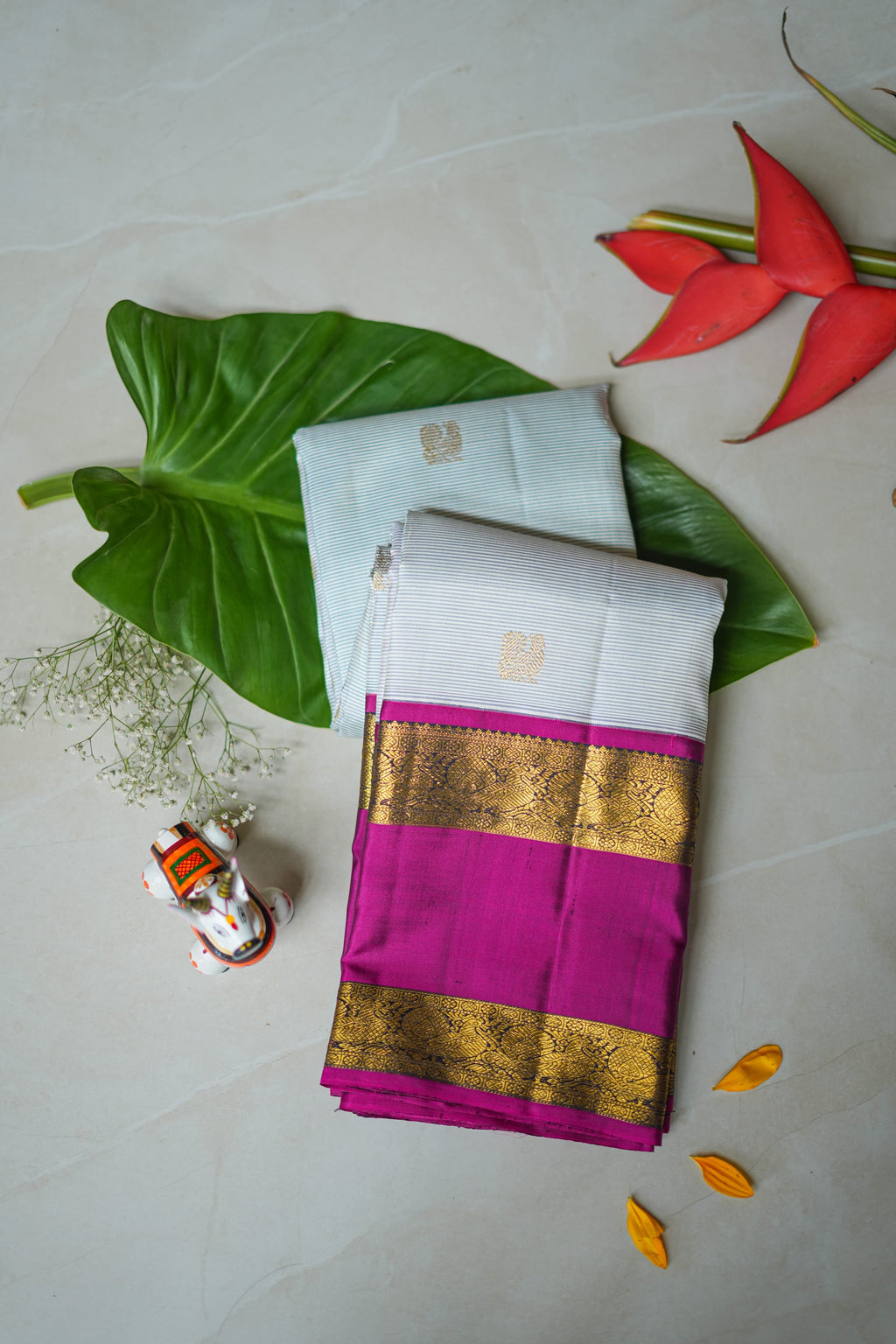 Ivory Silk Saree with Magenta Border: ivory silk with small gold butas and a magenta and gold zari border (folded)