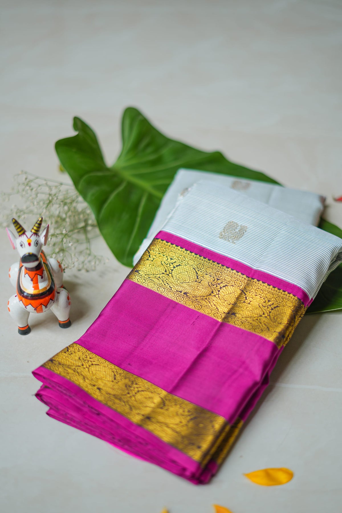 Ivory Silk Saree with Magenta Border: ivory silk with small gold butas and a magenta and gold zari border (folded)