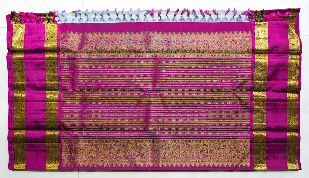 Ivory Silk Saree with Magenta Border: ivory silk with small gold butas and a magenta and gold zari border (laid flat)