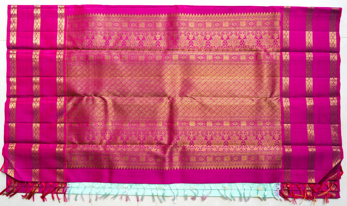 Kamala silk saree: aqua silk with a rani pink zari border (laid flat)