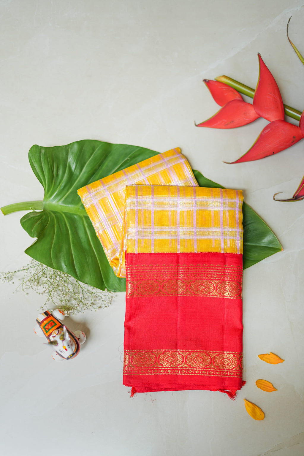Kumkuma silk saree: vermilion silk, gold zari border, mustard check pallu (folded)