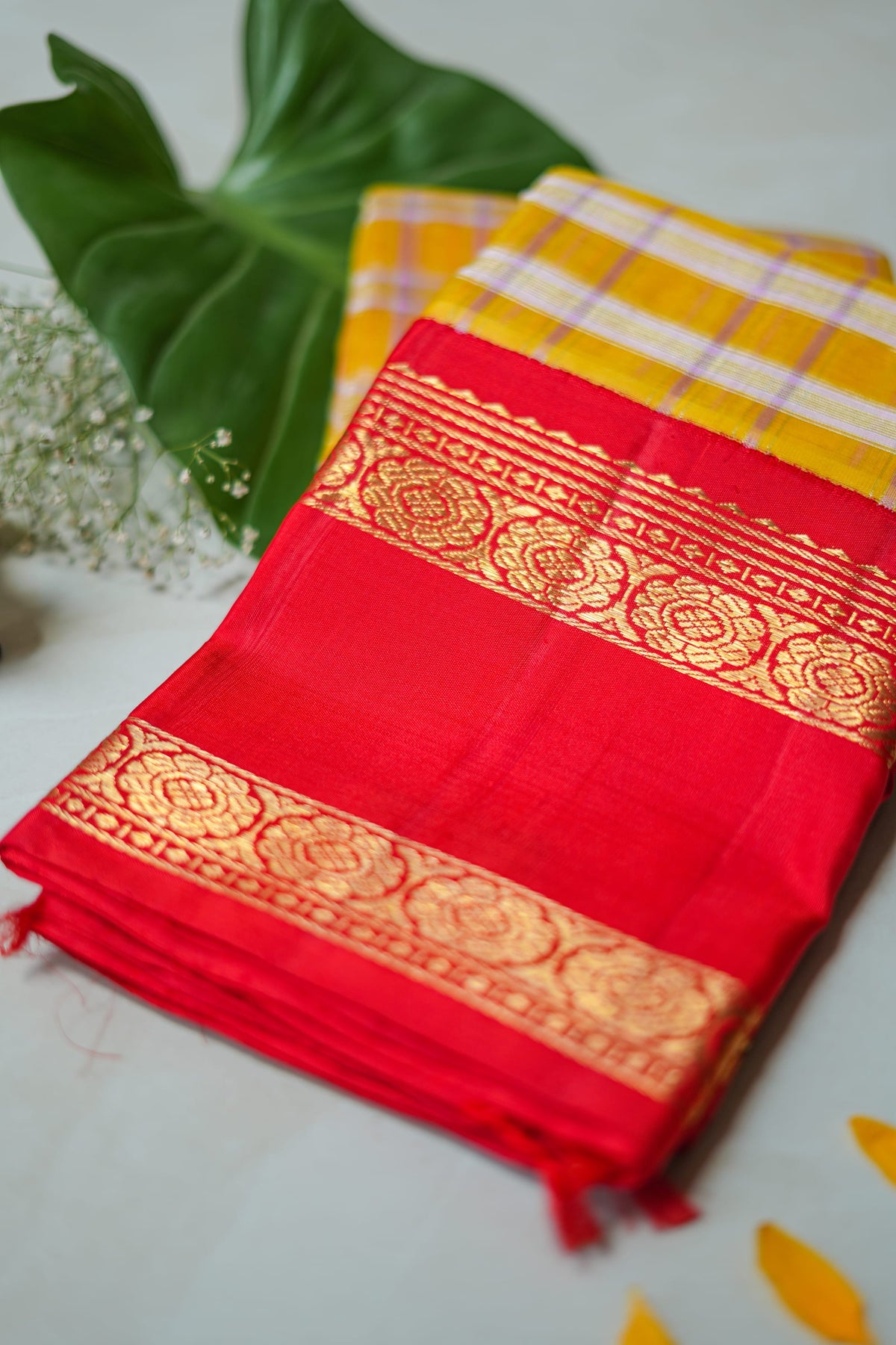 Kumkuma silk saree: vermilion silk, gold zari border, mustard check pallu (folded)