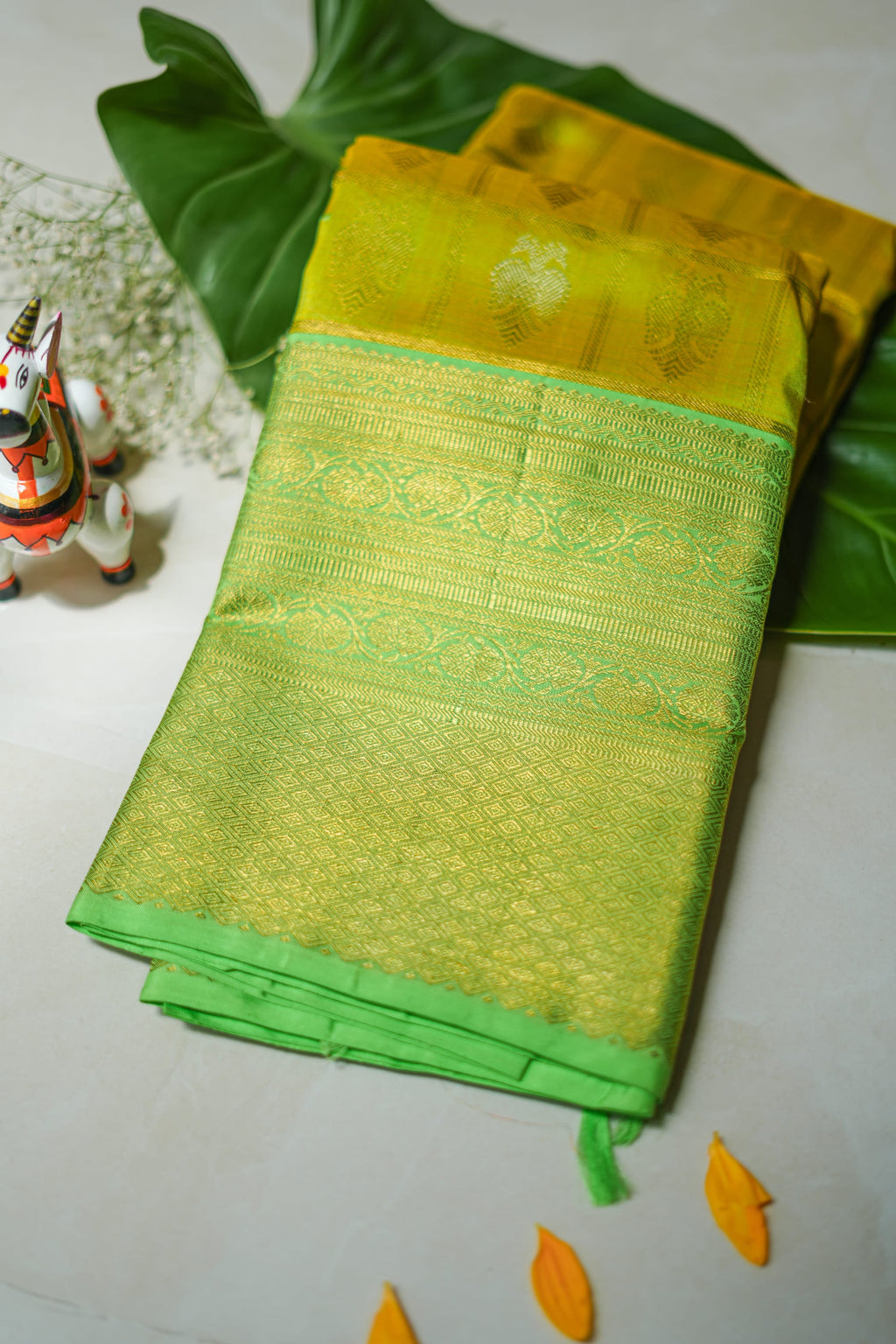 Lemon Yellow Silk Saree with Lime Green Border: lemon-yellow silk with gold butas and a lime-green zari border (folded)
