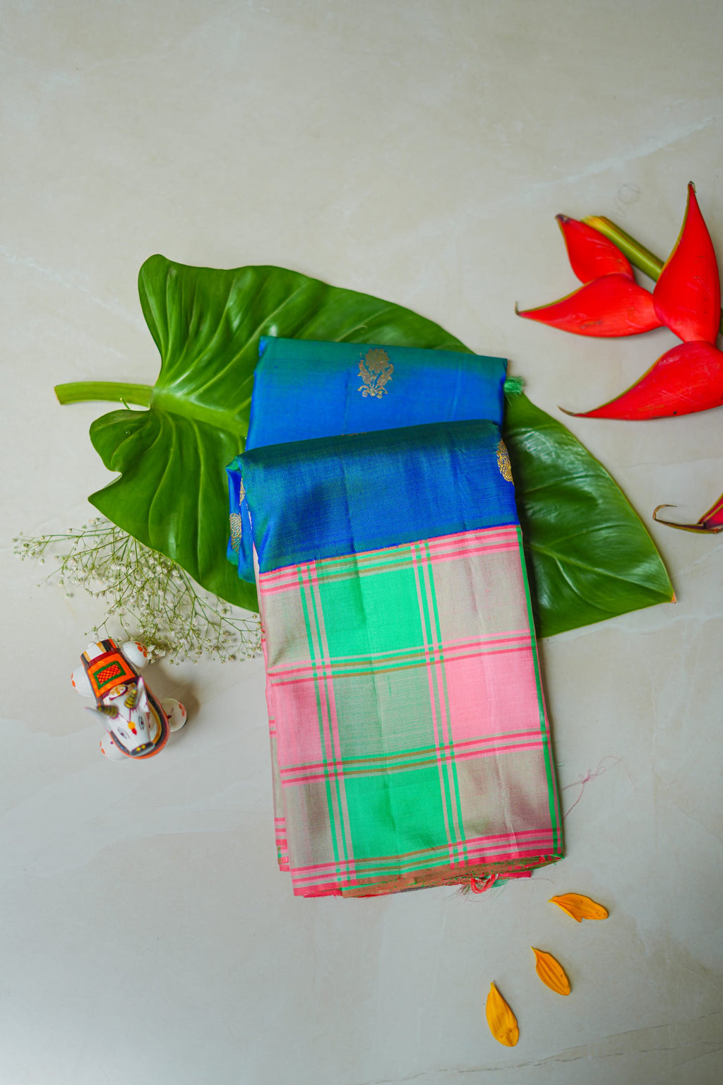 Mint & Pink Checked Silk Saree: mint-green and pink checks with gold butas and a royal-blue edge (folded)