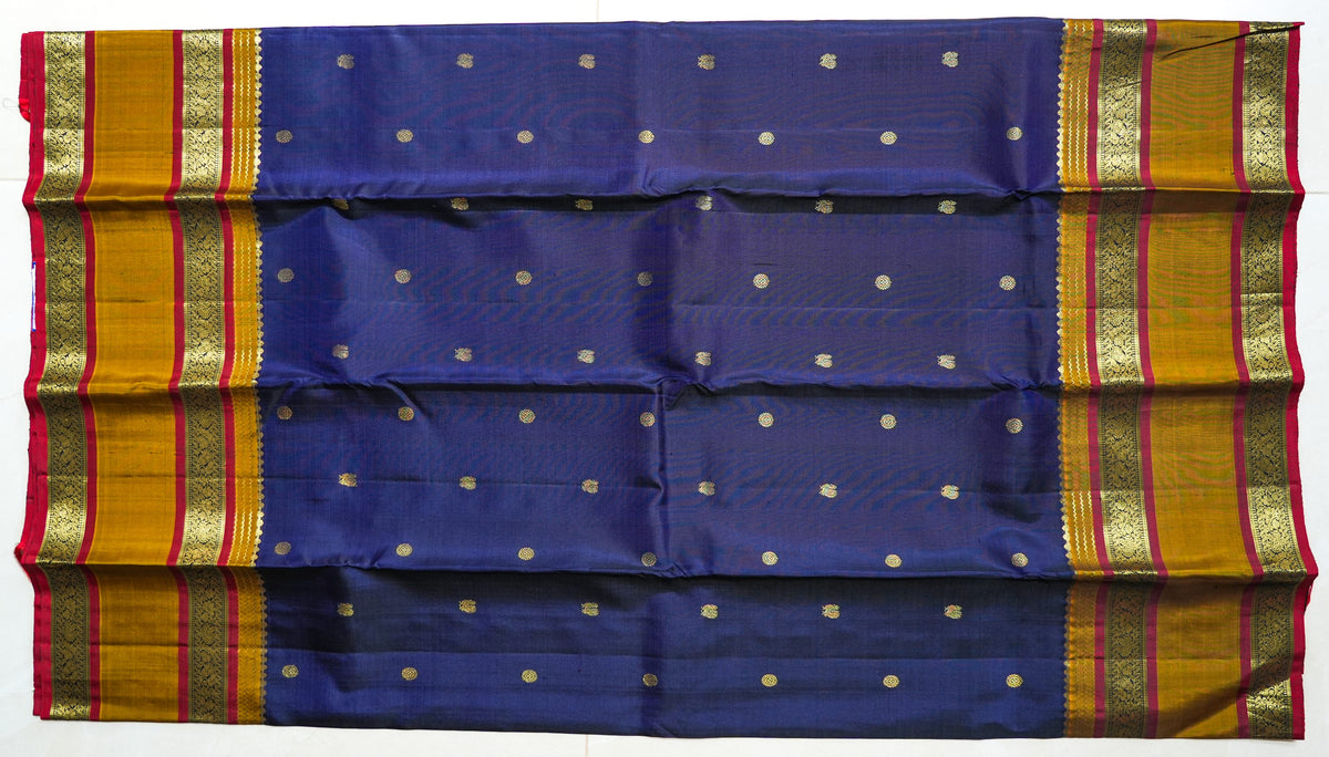 Navy Silk Saree with Mustard Border: navy silk with gold butas, a mustard and red zari border and a peach brocade pallu (laid flat)