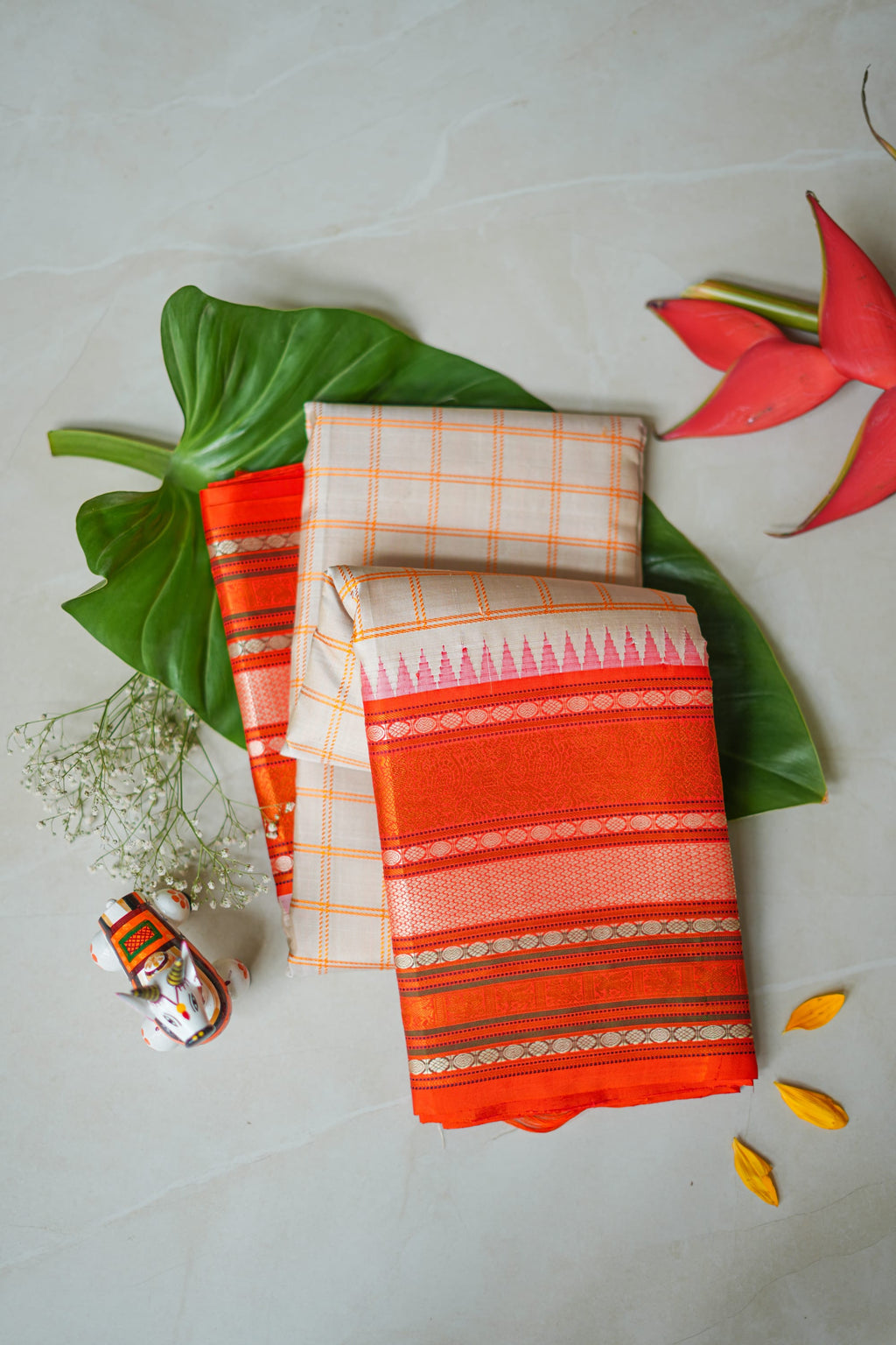 Sindhoora silk saree: peach checks with a vermilion temple border (folded)