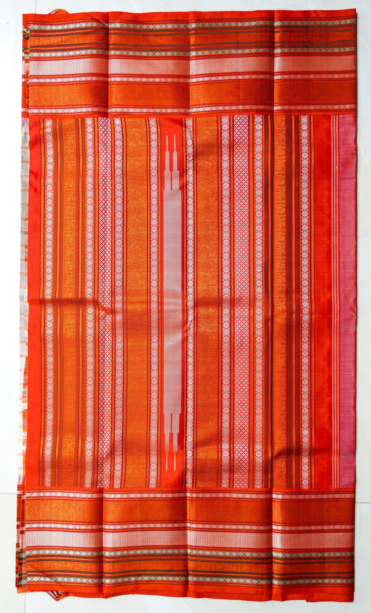 Sindhoora silk saree: peach checks with a vermilion temple border (laid flat)