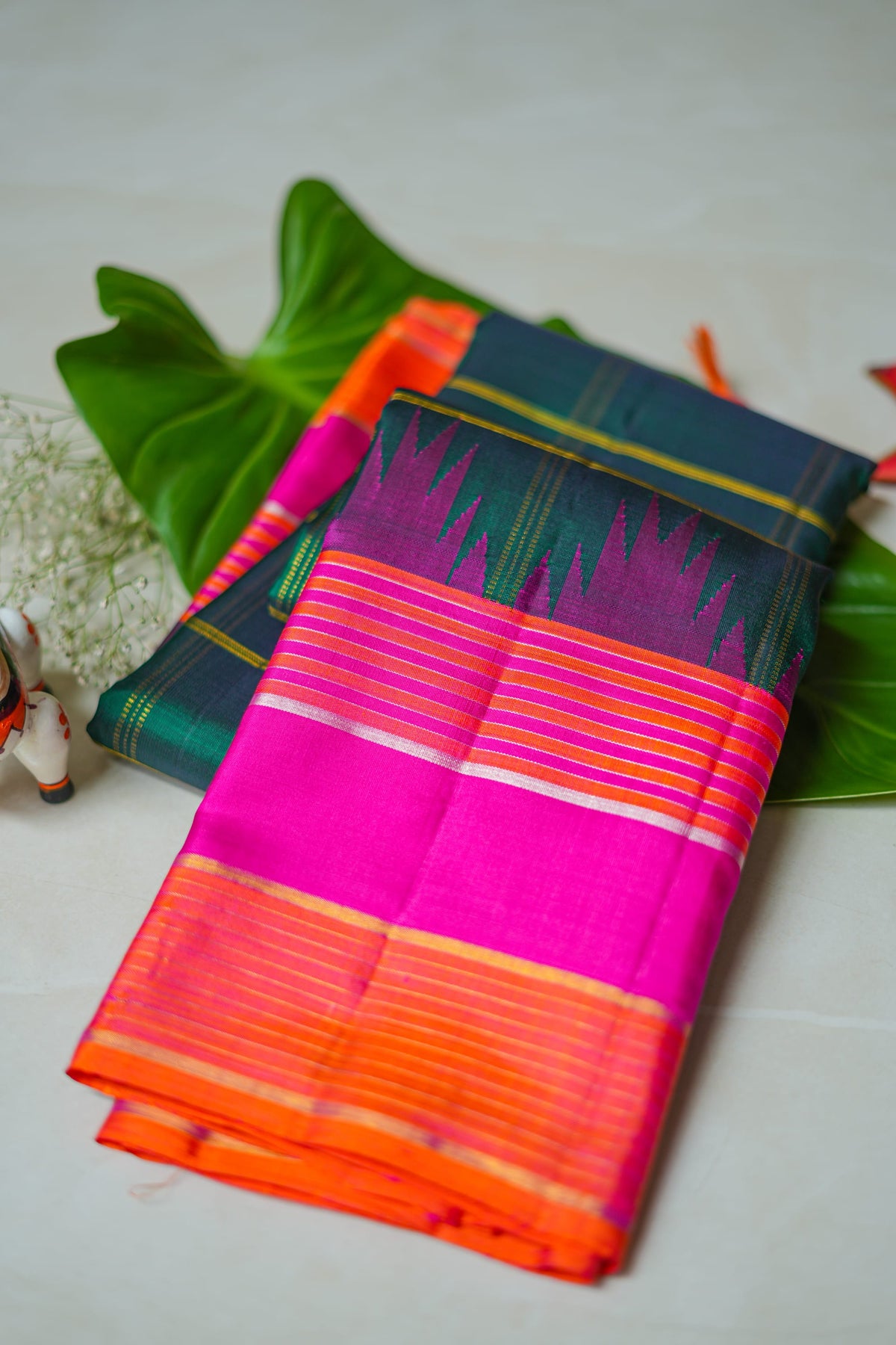 Teal Checked Silk Saree with Pink Temple Border: teal-green zari checks with a rani pink temple border and an orange edge (folded)
